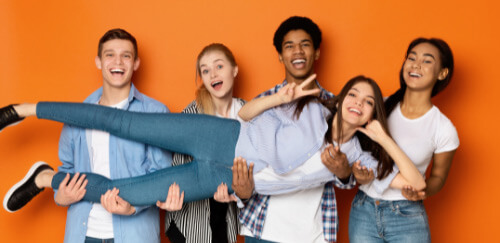 Photo of a group of kids holding up a girl